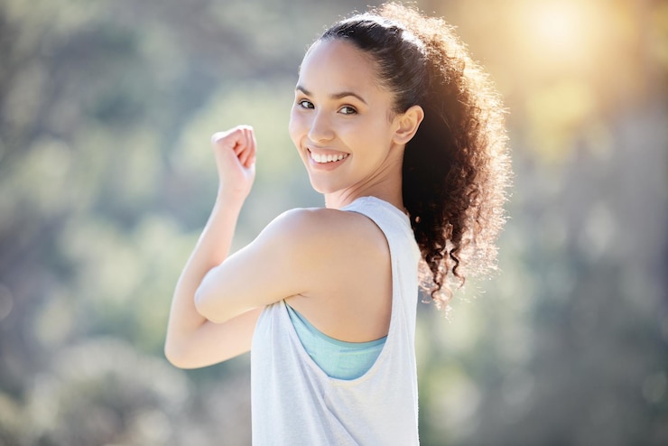 Foto sonrisa de retrato de mujer feliz y estirando los brazos para hacer ejercicio físico o hacer ejercicio al aire libre en la naturaleza persona femenina en forma o activa sonriendo en ejercicios de calentamiento o entrenamiento para un bienestar saludable