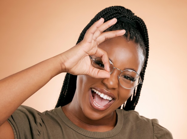 Sonrisa de retrato de mujer negra y signo de mano ok para perfecto o correcto contra el fondo del estudio Mujer afroamericana feliz sonriendo de felicidad mostrando un gesto de emoji bien para una actitud positiva