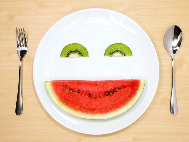 Sonrisa de sandía y kiwi servido en plato blanco