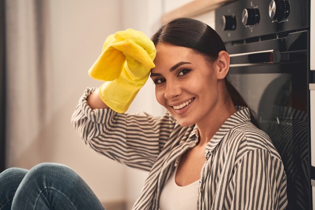 Foto sonrisa sincera. amable mujer morena manteniendo una sonrisa en su rostro mientras posa en el frente