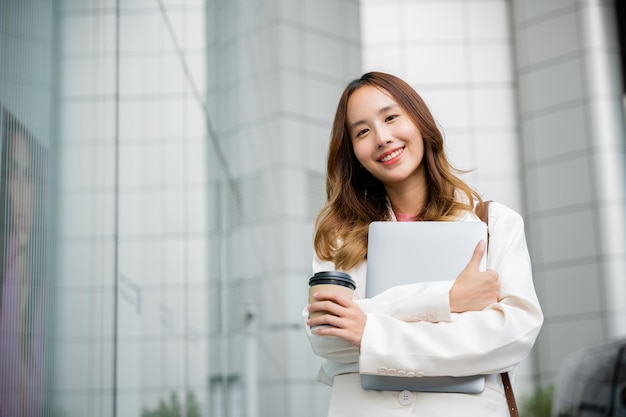 Sonrisa en su rostro y una taza de café caliente en la mano.