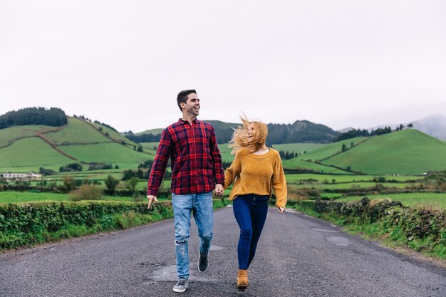 Las sonrisas sinceras de una pareja enamorada del camino y las montañas tienen han