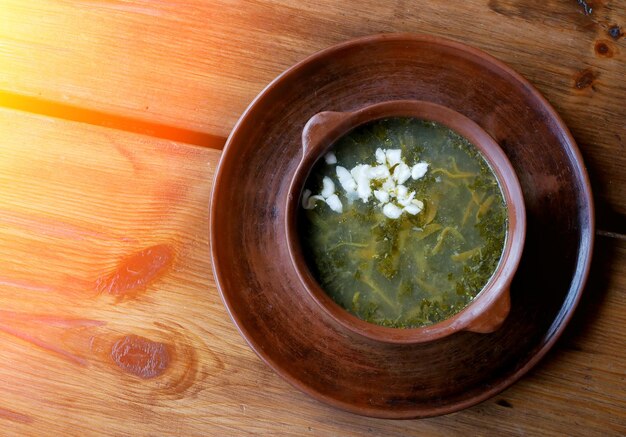 Sopa de acedera dietética con huevo sobre una mesa de madera