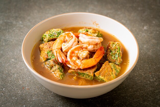 Sopa agria hecha de pasta de tamarindo con tortilla de camarones y vegetales, estilo de comida asiática