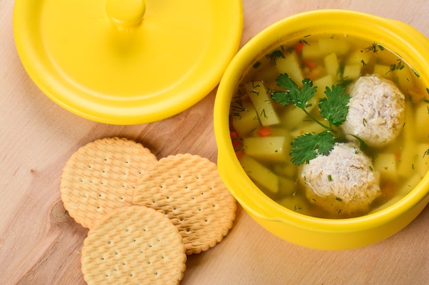 Foto sopa con albóndigas en una olla de porcelana