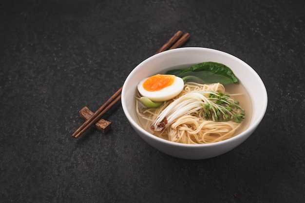 Sopa asiática macarrão (ramen) com ovo em fundo escuro