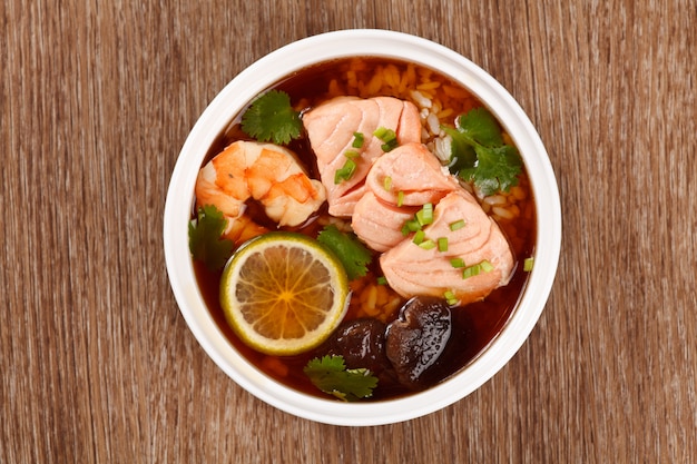 Sopa asiática con mariscos, salmón, camarones, limón, champiñones y arroz.