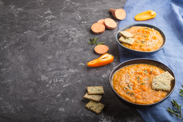 Sopa de batata o crema de batata con semillas de sésamo y bocadillos en tazones de cerámica