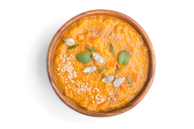 Sopa de batata o crema de batata con semillas de sésamo en un recipiente de madera aislado en un fondo blanco. vista superior.