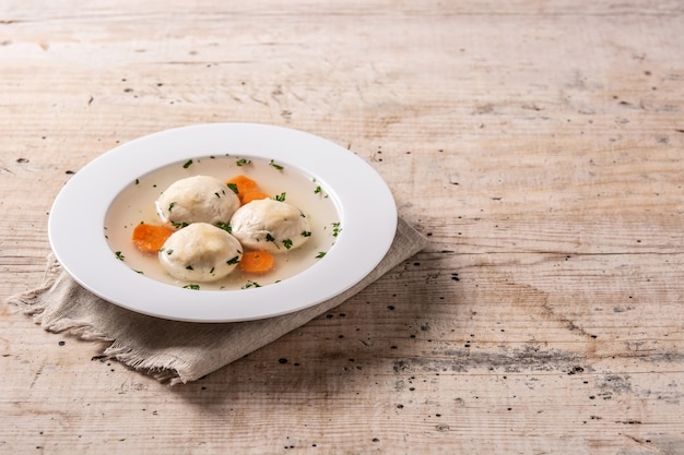 Sopa de bolas de matzá judía tradicional en mesa de madera