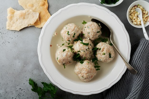 Sopa de bolas de matzá de pollo casera con perejil y ajo