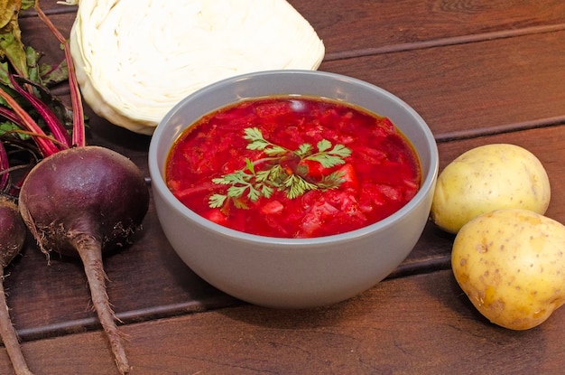 Sopa de borscht con verduras y carne en una mesa de madera