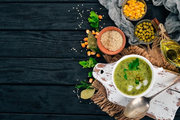 Sopa con brócoli y guisantes y verduras en un bol Comida sana Sobre un fondo de madera negra Vista superior Copiar espacio para el texto