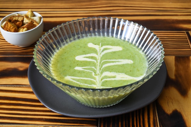 Sopa de brócoli en mesa de madera con vista lateral de galletas