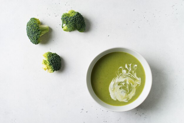 Sopa de brócoli de verduras verdes sobre blanco, vista superior