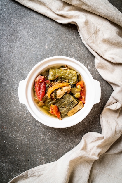 Sopa de calabaza amarga y verde mostaza en conserva con carne de cerdo