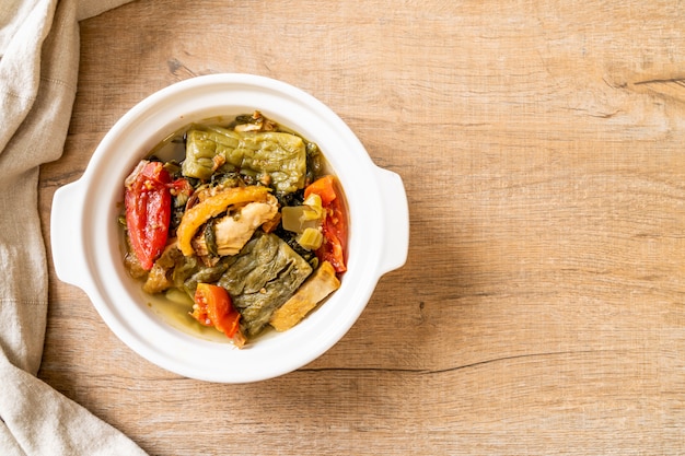 Sopa de calabaza amarga y verde mostaza en conserva con carne de cerdo