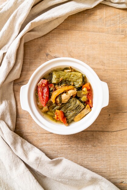 Sopa de calabaza amarga y verde mostaza en conserva con carne de cerdo