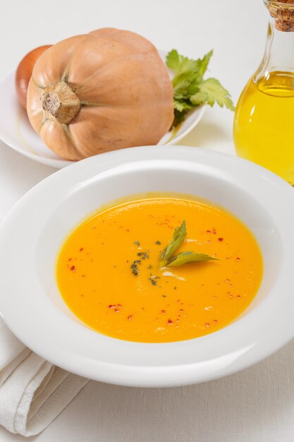 Sopa de calabaza y calabazas orgánicas en el cuadro blanco. Comida de temporada de otoño: sopa picante de calabaza y zanahoria.