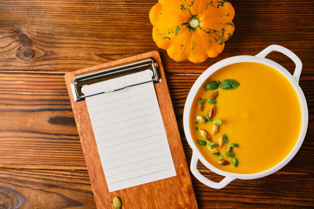 Sopa de calabaza casera con crema en un plato de caldo blanco