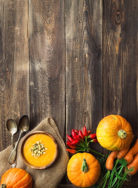 Sopa de calabaza casera fresca con ingredientes sobre fondo rústico de madera. Vista superior. Copie el área del espacio.