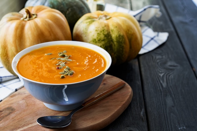 Sopa de calabaza casera sobre una mesa negra oscura