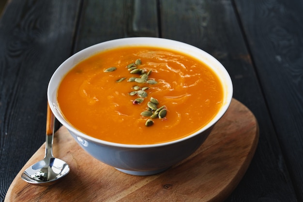 Sopa de calabaza casera sobre una mesa negra oscura