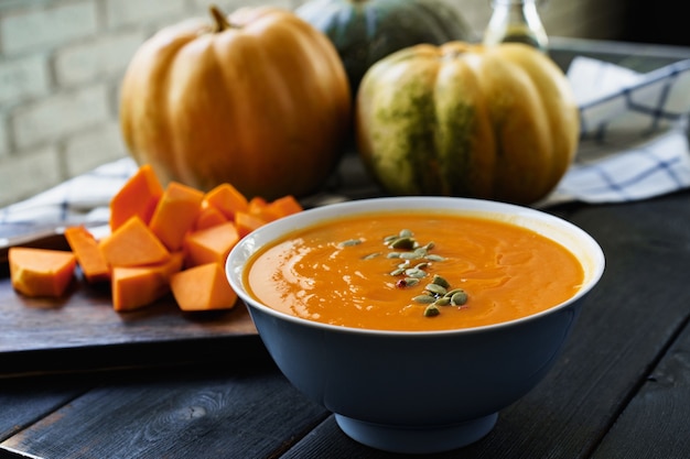 Sopa de calabaza casera sobre una mesa negra oscura