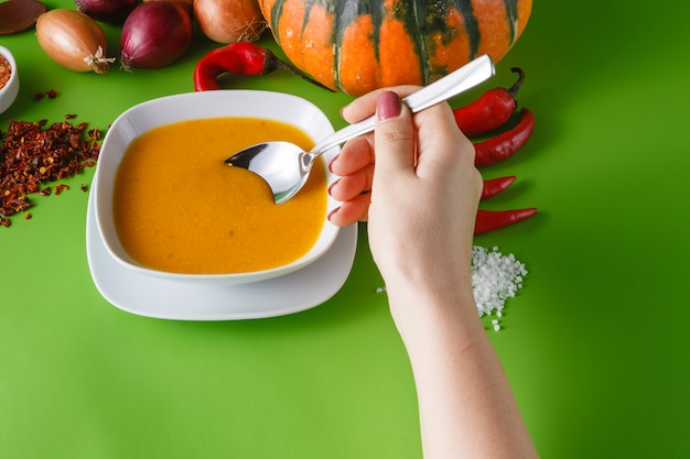 Sopa de calabaza con cebolla y pimiento sobre fondo verde sin sombras