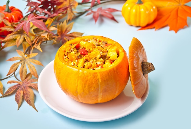 Sopa de calabaza cocida fresca servida en calabaza. Otoño comida cálida y acogedora.