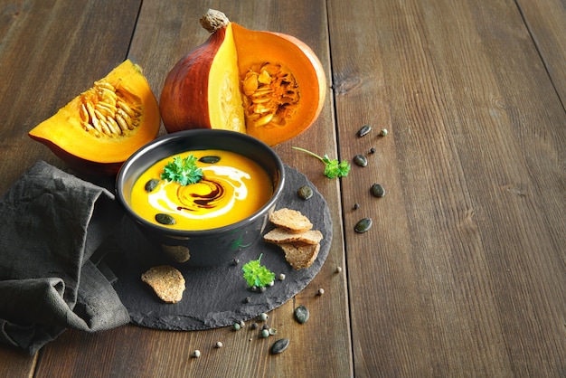 Foto sopa de calabaza picante servida en un frasco con aceite de calabaza y picatostes