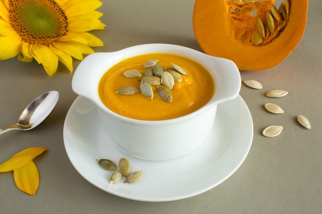 Sopa de calabaza en el plato blanco sobre gris