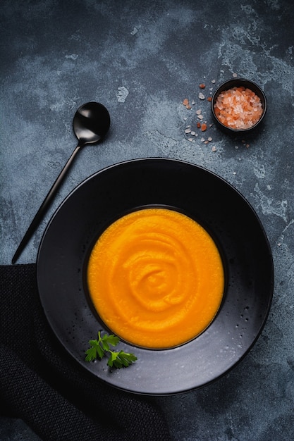 Sopa de calabaza en plato de cerámica negra