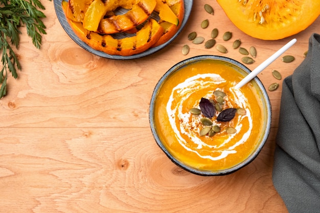 Sopa de calabaza en un plato sobre una superficie de madera