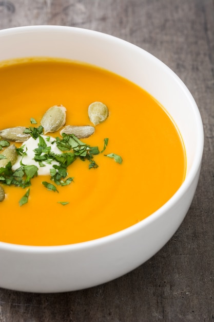 Sopa de calabaza en un recipiente en la mesa de madera