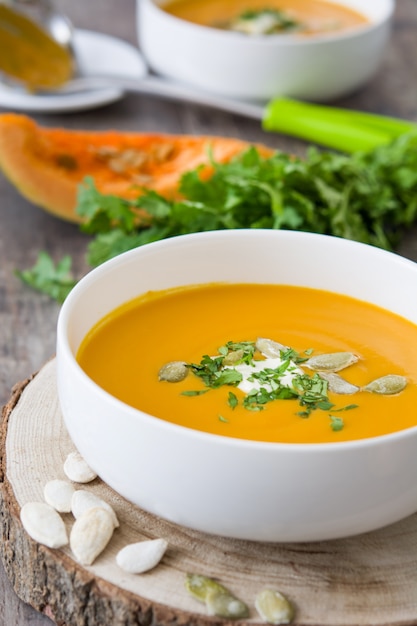 Sopa de calabaza en un recipiente en la mesa de madera