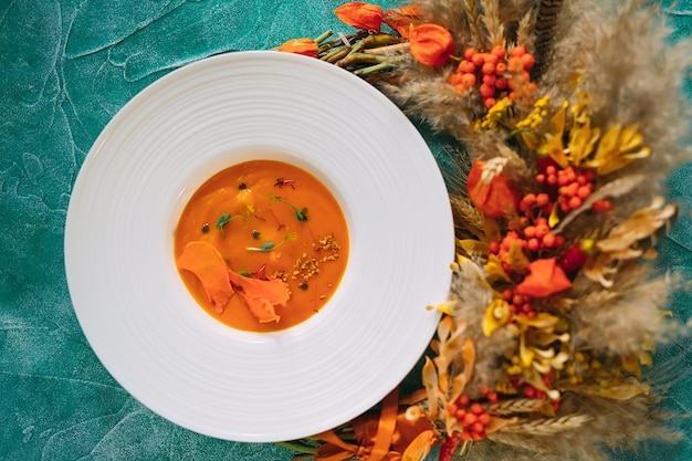 Foto sopa de calabaza sobre un fondo verde. la vista desde la cima.