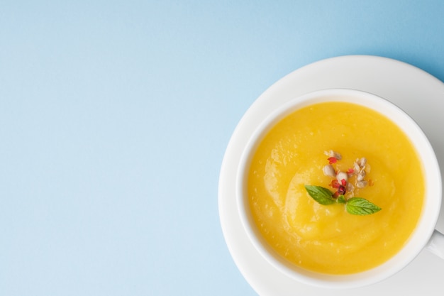 Sopa de calabaza triturada con especias en una taza.