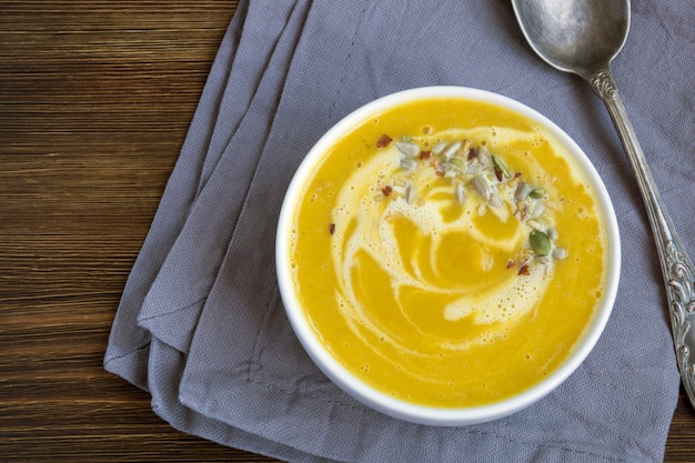 Sopa de calabaza vegetariana en una mesa de madera.