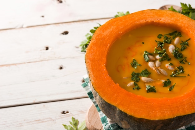 Foto sopa de calabaza y zanahoria en mesa de madera.