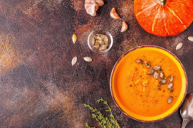 Sopa de calabaza y zanahoria servida con semillas, vista superior.