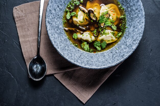 Sopa de caldo de pollo wonton con champiñones y hierbas