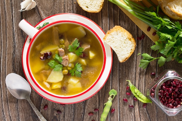 Sopa de carne y verduras frescas en una mesa de madera