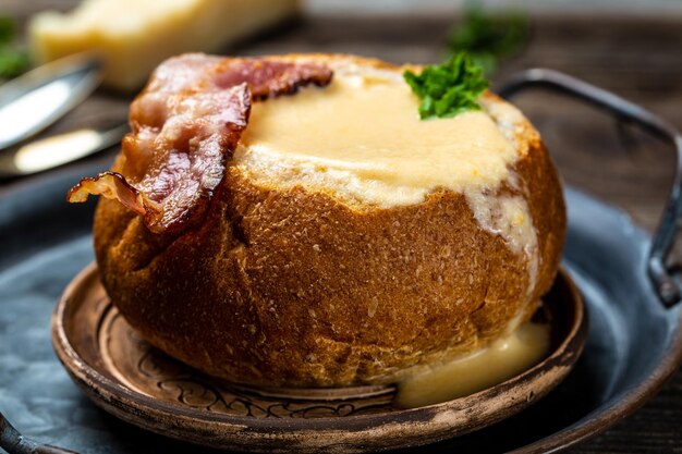 Sopa caseira de brócolis e queijo cheddar em uma tigela de pão sopa de creme de queijo servida com colher Fundo de receita alimentar Fechar