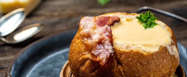 Sopa caseira de brócolis e queijo cheddar em uma tigela de pão sopa de creme de queijo servida com colher fundo de receita alimentar fechar