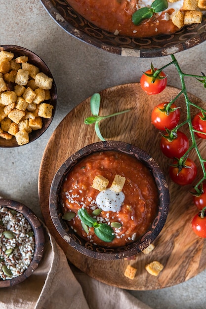 Sopa caseira de tomate com croutons e microgreen em uma tigela de madeira