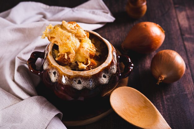 Sopa de cebolla casera con croutons de queso en una olla en la mesa