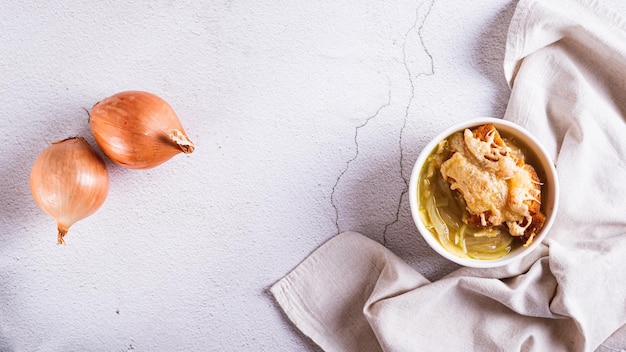 Sopa de cebolla francesa con pan de queso horneado en un cuenco en la mesa