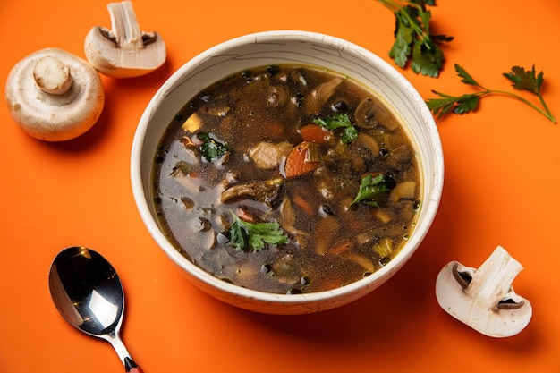 Sopa de champiñones con cebada perlada Con breav negro y perejil vista superior mesa de cocina gris