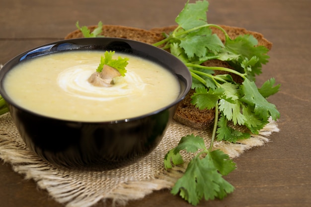 Sopa de champiñones hecha en casa de la dieta en una tabla de madera.